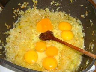 Jak udělat chlupaté knedlíky s vajíčky | recept Vrátíme se k cibulce. Kastrol můžeme přemístit na horkou plotýnku, kde se vařily knedlíky. Zahřejeme tuk a na cibulku vlijeme syrová vajíčka. Je lepší jedno každé rozklepnout nad „kontrolní“ miskou, abychom případně včas eliminovali vejce špatné a nezkazili si jím všechny ostatní suroviny. Na jednu porci počítáme jedno až dvě vejce – podle toho, jak vzácná nám vajíčka jsou. Mírně osolíme a usmažíme, mohou být i tužší.